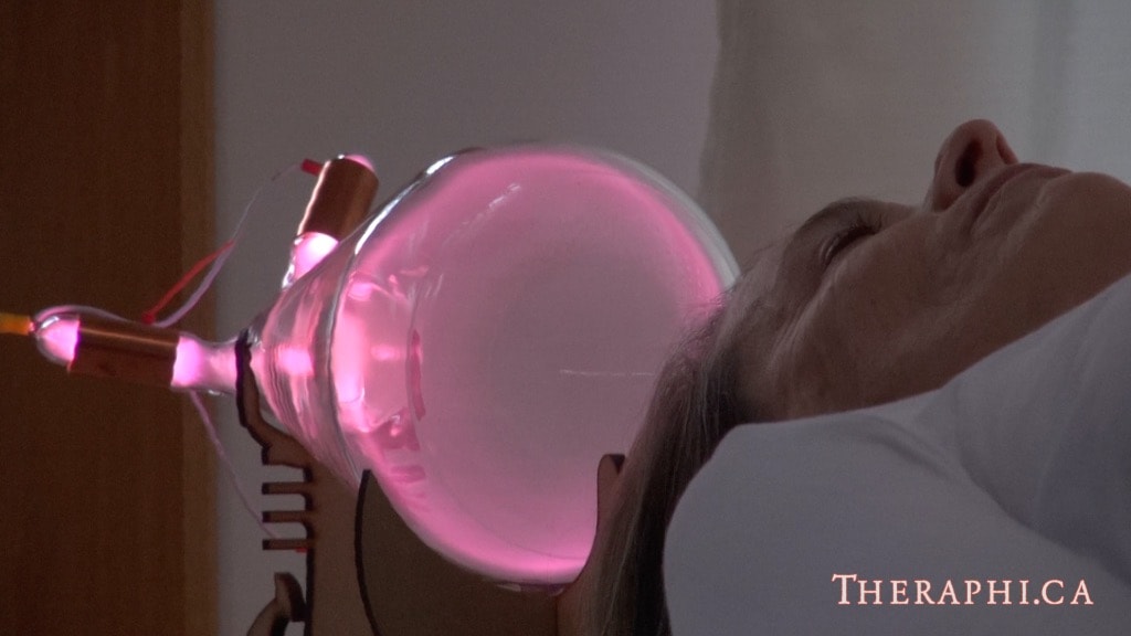 Close-up of face next to glowing Theraphi plasma bulb